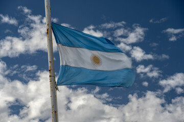 Argentinian flag waving in sky with clouds.