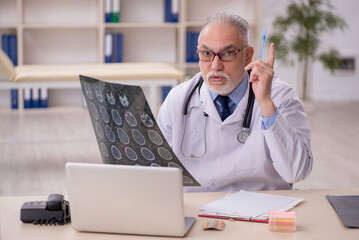 Old male doctor radiologist working in the clinic