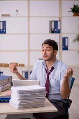 Young male employee and too much work in the office