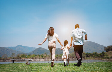 Happy family in the nature travel. family on weekend playing together in the meadow with river Parents hold the child and daughter hands.health life insurance plan concept.