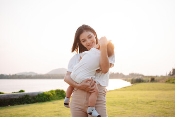 Mother Parenting and newborn birth life. Mom and baby boy playing in park sunset, Family having fun...