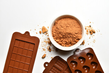Cocoa in a bowl and molds for making chocolate.