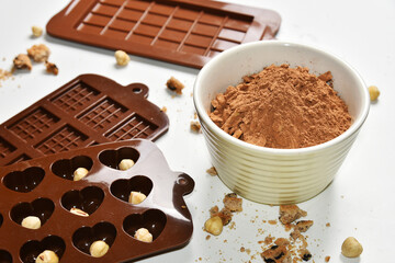 Cocoa powder, nuts and cookie crumbs, silicone molds for making chocolate, home made food sweetness cookie