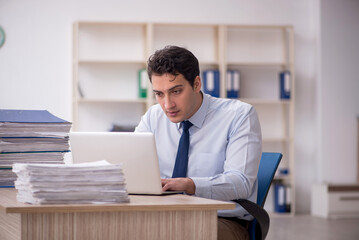 Young male employee and too much work in the office