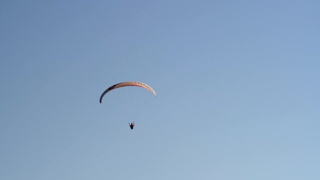 Single paraglider flying against the blue sky. Extreme sports - paragliding in the sky