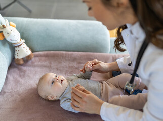 Obraz na płótnie Canvas Young pediatrician checking little baby