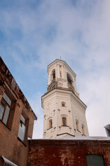 Fototapeta na wymiar View of old Clock Tower on sunny winter day. Belfry of Vyborg Cathedral, Vyborg, Russia