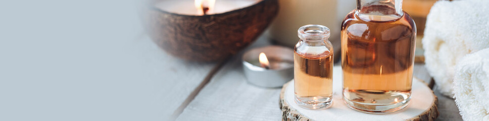 Concept of spa treatment in salon with pure organic natural oil. Atmosphere of relax, detention. Aromatherapy, candles, towel, wooden background. Skin care, body gentle treatment