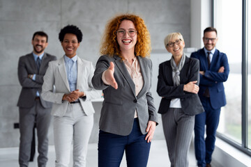 Portrait of multicultural business team standing in office together