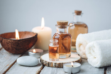 Concept of spa treatment in salon with pure organic natural oil. Atmosphere of relax, detention. Aromatherapy, candles, towel, wooden background. Skin care, body gentle treatment - obrazy, fototapety, plakaty
