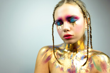 Glamour fashion model with bright gloss make-up posing at studio. Young woman with fantasy bright...