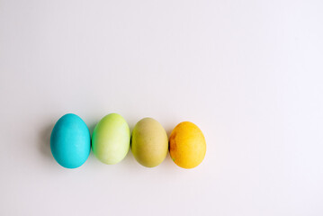 Easter bright, blue, green, orange eggs lie in a row on an isolated white background. Greeting card