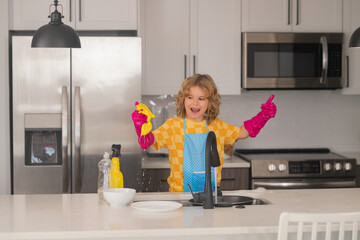Clean dishes. Cute child helping with household, wiping dishes in kitchen. Adorable little helper...