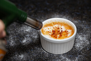 Traditional creme brulee on rustic surface and selective focus