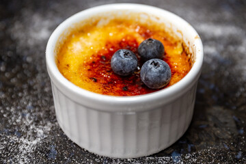 Traditional creme brulee on rustic surface and selective focus
