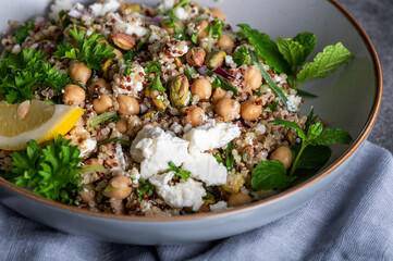 Healthy Salad made from Quinoa, Cucumber, Herbs, Pistachios, Chickpeas and Feta with lemon juice and olive oil. So called Jennifer Aniston Salad, fresh, crunchy, and packed with plant-based protein