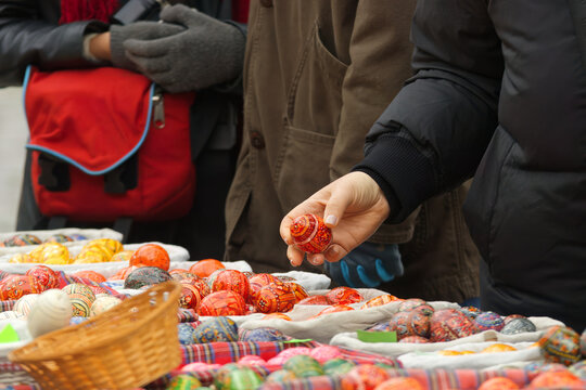 Customers choose and buy painted eggs, traditional Easter decorations at the farmers street market in Prague