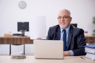 Old male employee working in the office
