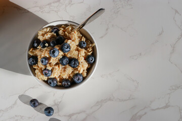 top view of healthy vegan oatmeal with blueberries in white porcelain bowl 
