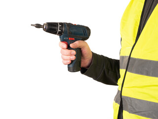 A worker in a safety vest holds a cordless screwdriver in his hand. No face, white background, copy space. 