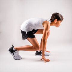 Obraz premium Young male track runner crouching in the starting position ready to run a race