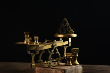 Black caviar is on the scales. Black caviar. A delicacy of sturgeon fish. Brass antique scales. A symbol of wealth and luxurious life.A useful omega.