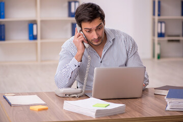 Naklejka premium Young male employee working in the office