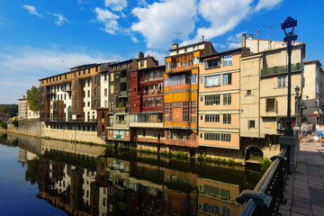 Obraz premium View of typical colored old residential townhouses built on water on bank of Agout river in historic center of Castres town on summer day, France