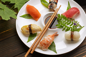 Delicious sushi rolls with wasabi and ginger with chopsticks