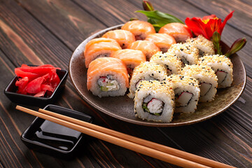 Delicious sushi rolls with wasabi and ginger with chopsticks