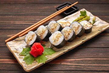 Delicious sushi rolls with wasabi and ginger with chopsticks