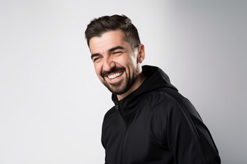 Obraz premium Portrait of a happy young man in black sportswear on gray background