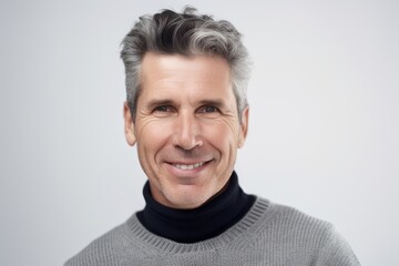 Fototapeta premium Portrait of handsome middle-aged man smiling at camera over grey background