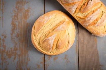 bread on a board, two freshly baked loaves, freshly baked bread on a wooden table