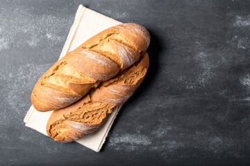 fresh bread on table, two freshly baked loaves, freshly baked bread on top of a tea towel on a black stone table