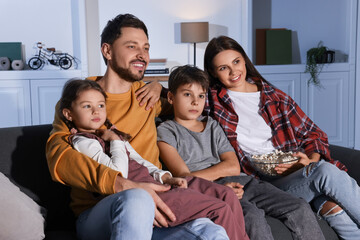 Family watching TV at home in evening