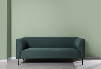 Comfortable sofa near light green wall indoors