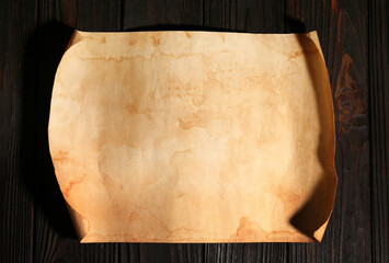 Sheet of old parchment paper on wooden table, top view