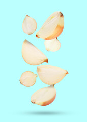 Cut onions falling on pastel light blue background