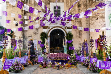 Iglesia que celebra semana santa con adornos florales, papel picado e imágenes religiosas. 