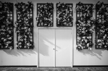 Building Wall with Flowers on a Trellis and Double Doors.