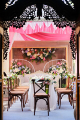 A wedding reception with a pink curtain that says'love is in the background '