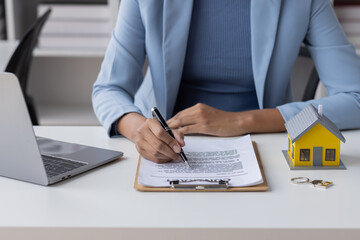 Fototapeta premium Real estate broker agent presenting and consult to customer to decision making sign insurance form agreement, buy and sell home model, concerning mortgage loan offer for and house insurance 