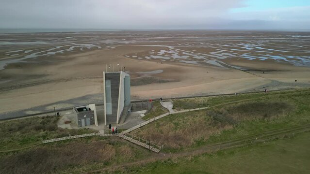 Reveal of sand flats and cloudy horizon at National Coastwatch Initiative Rossall Point Fleetwood