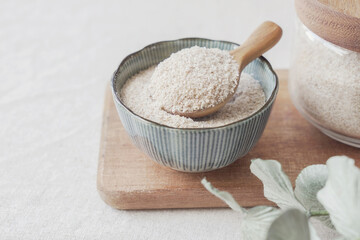 Psyllium husk in wooden spoon and bowl on wooden plate, superfood fiber prebiotic food for gut...