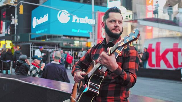 A Musician Is Performing Live In Timesquare New York On His Acoustic Guitar