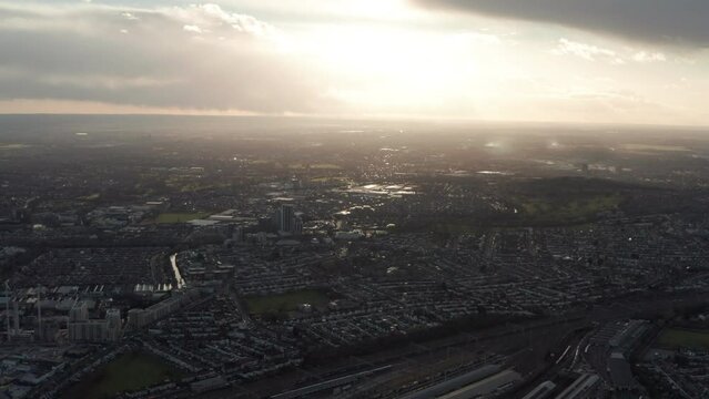 High aerial shot over sprawling London suburbs at sunset