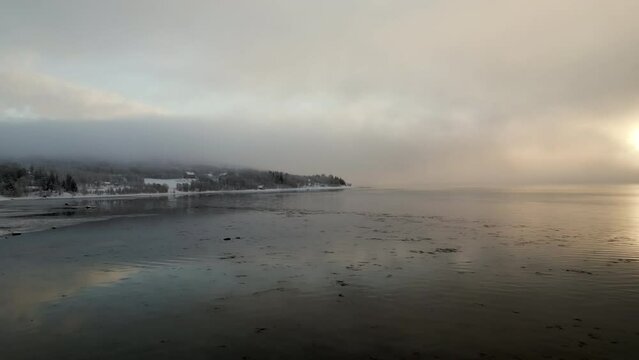 Norwegian Fjord at sunset on cloudy day. Aerial drone forward low altitude