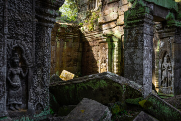 Lights shining on crumbling walls, towers and stone carvings at Ta Prohm temple in Siem Reap, Cambodia