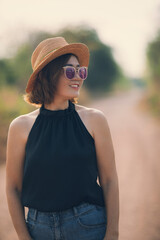 beautiful asian woman wearing straw hat standing outdoor with toothy smiling face